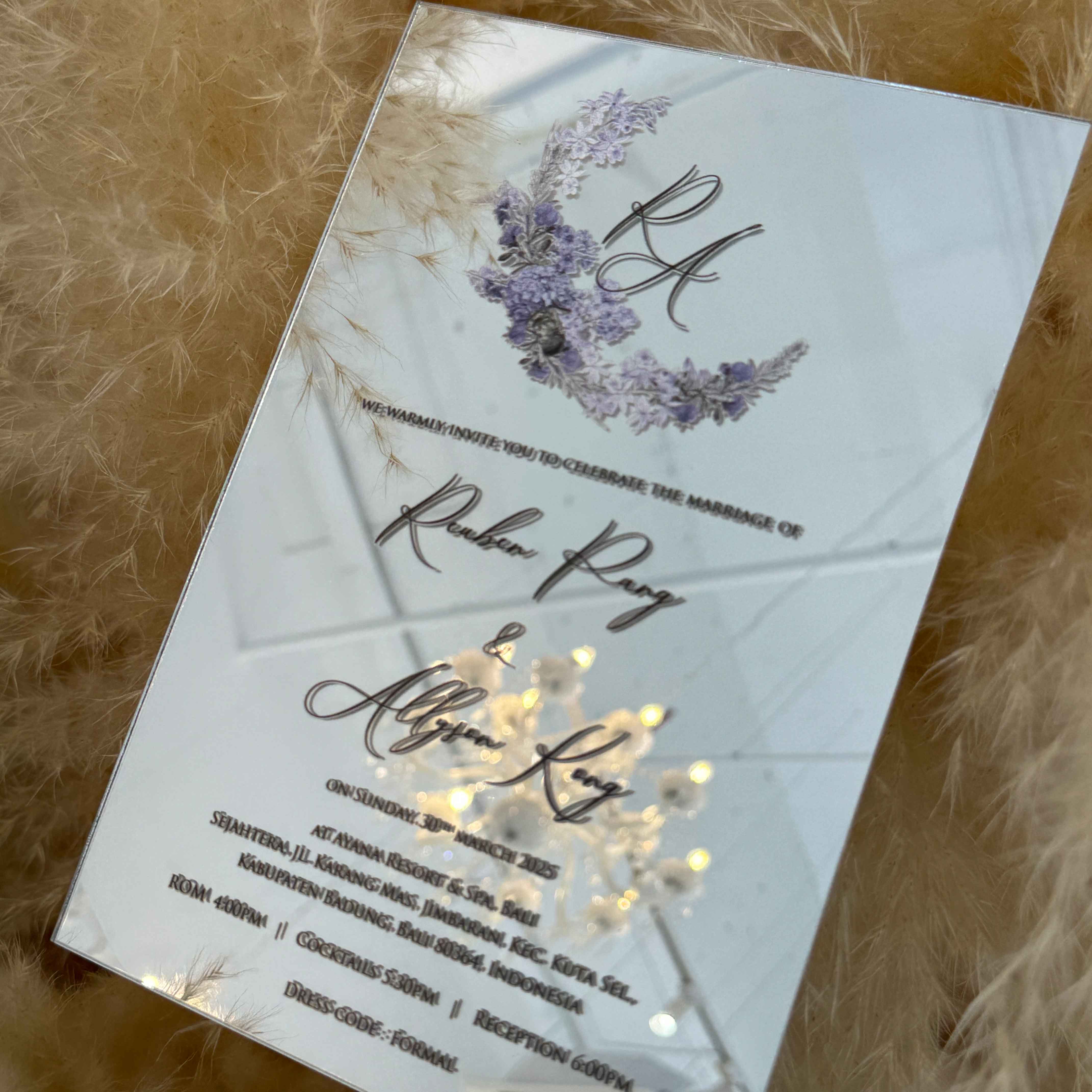 Clear wedding invitation with floral design on a textured surface
