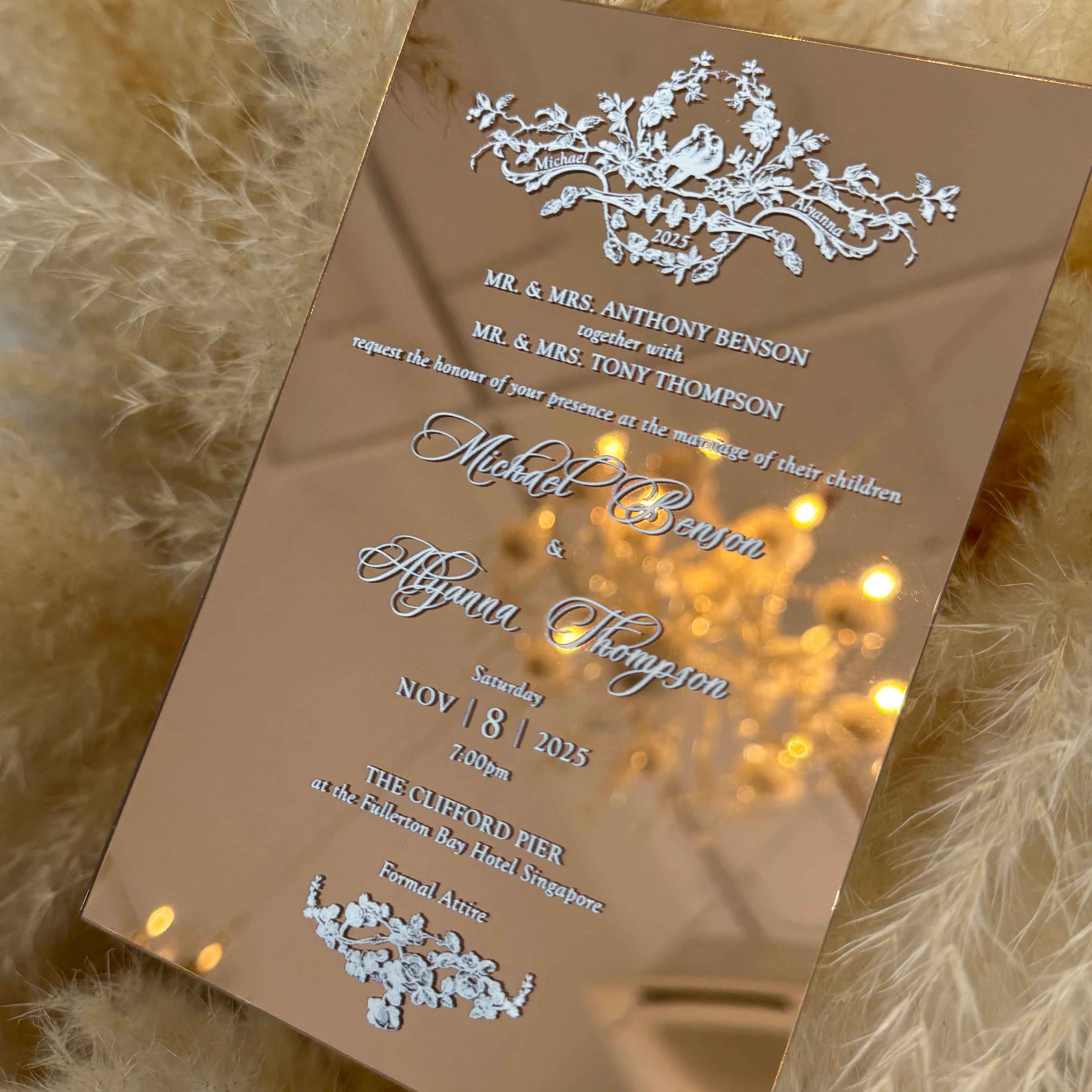 Acrylic wedding invitation card with decorative elements on a textured surface with lights.
