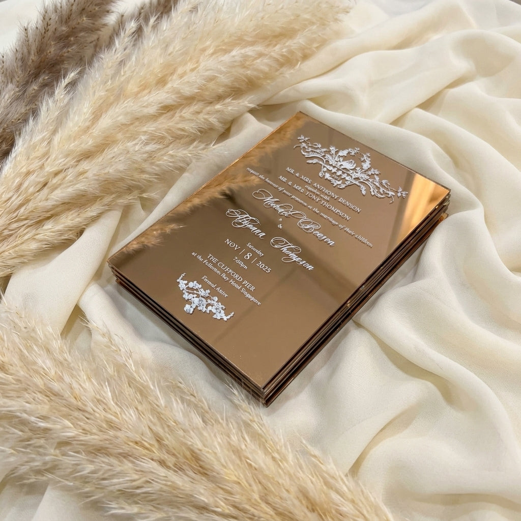 Bronze colour mirror acrylic wedding invitation with floral design on a textured beige surface