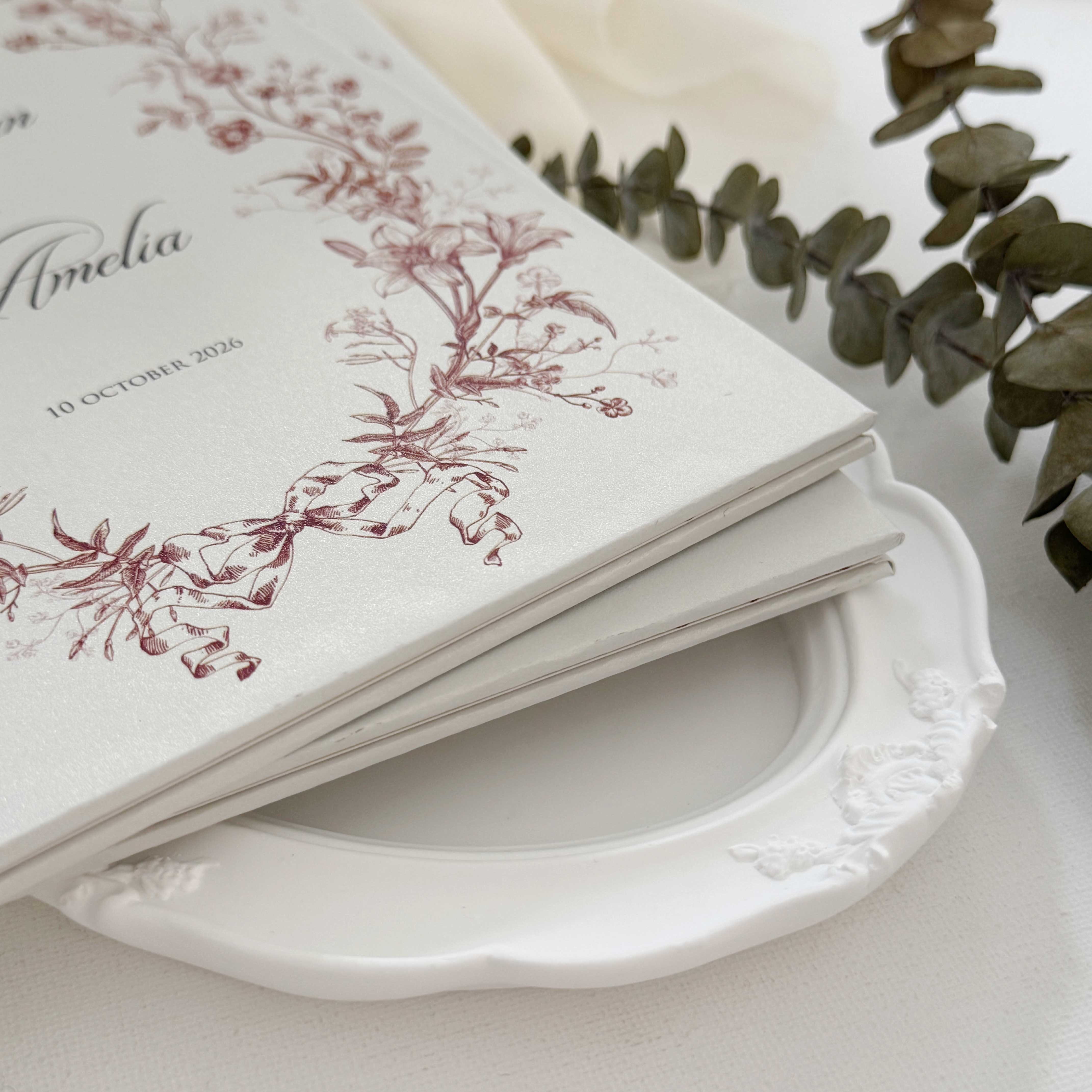 Hardcover wedding invitations offer a premium, book-like luxury presentation that makes a lasting statement for high-end ceremonies. Built on durable rigid chipboard, these invitations are often paired with high-end textures like matte laminate, velvet, or suede, and are finished with elegant hot foil stamping.