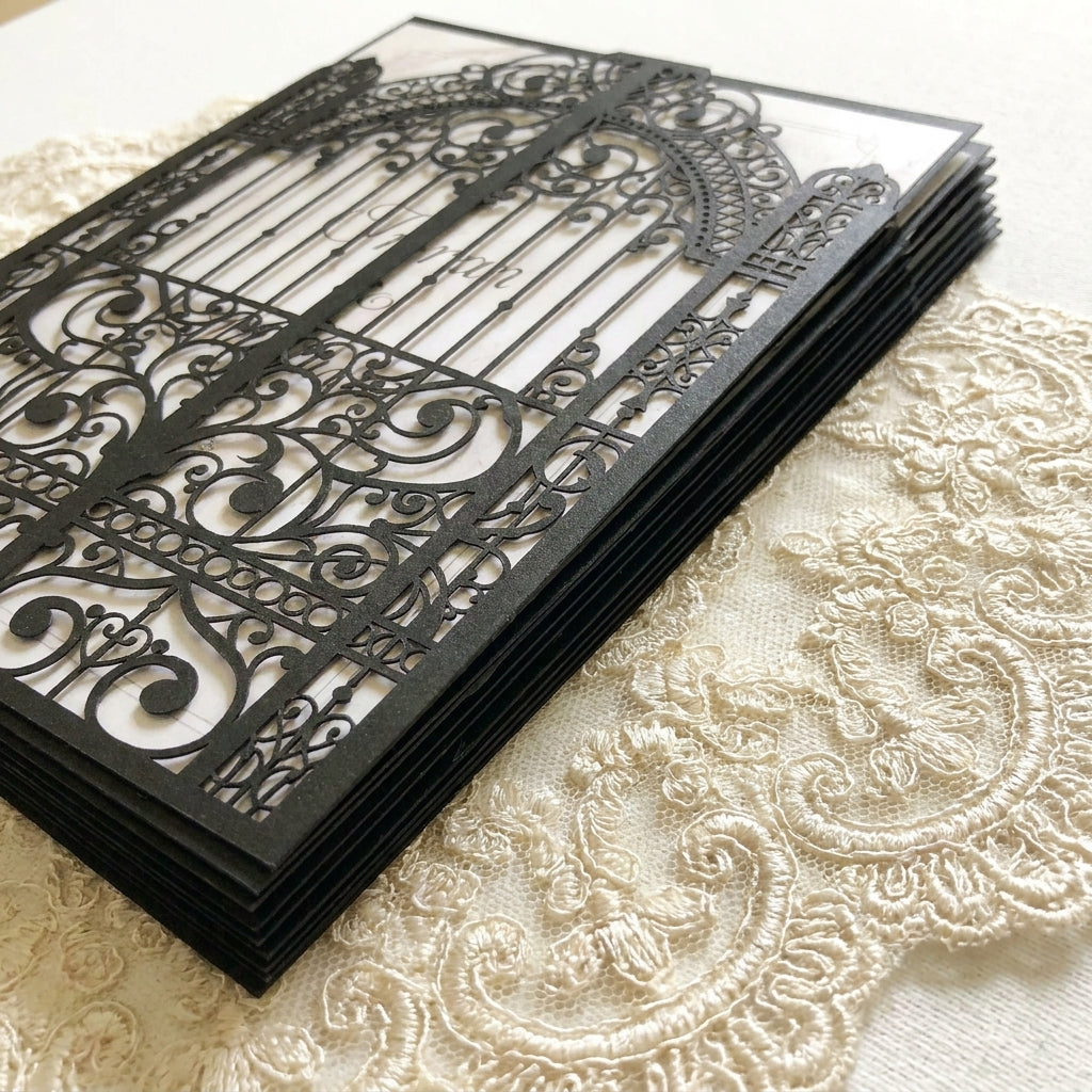 Decorative black laser cut wedding invitation on a textured beige surface