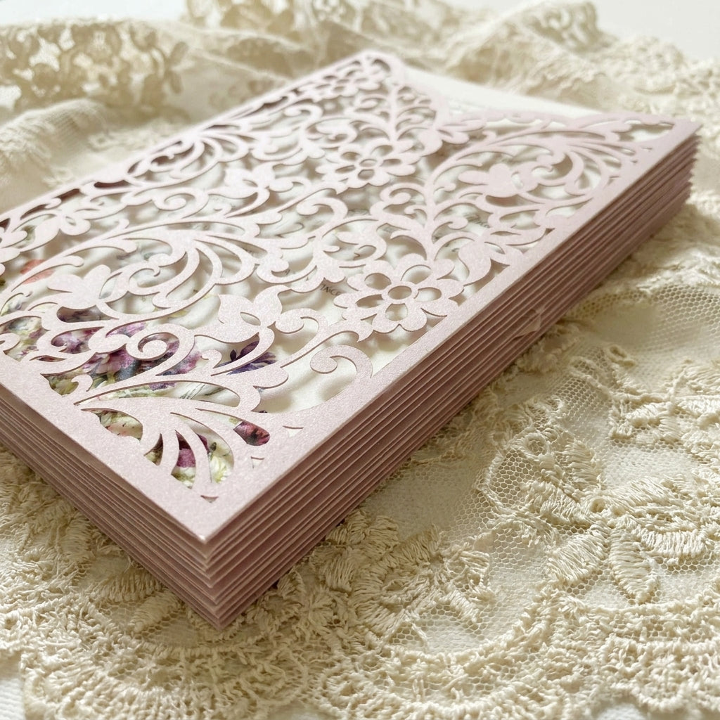 Lilac laser-cut wedding cards on a lace fabric background