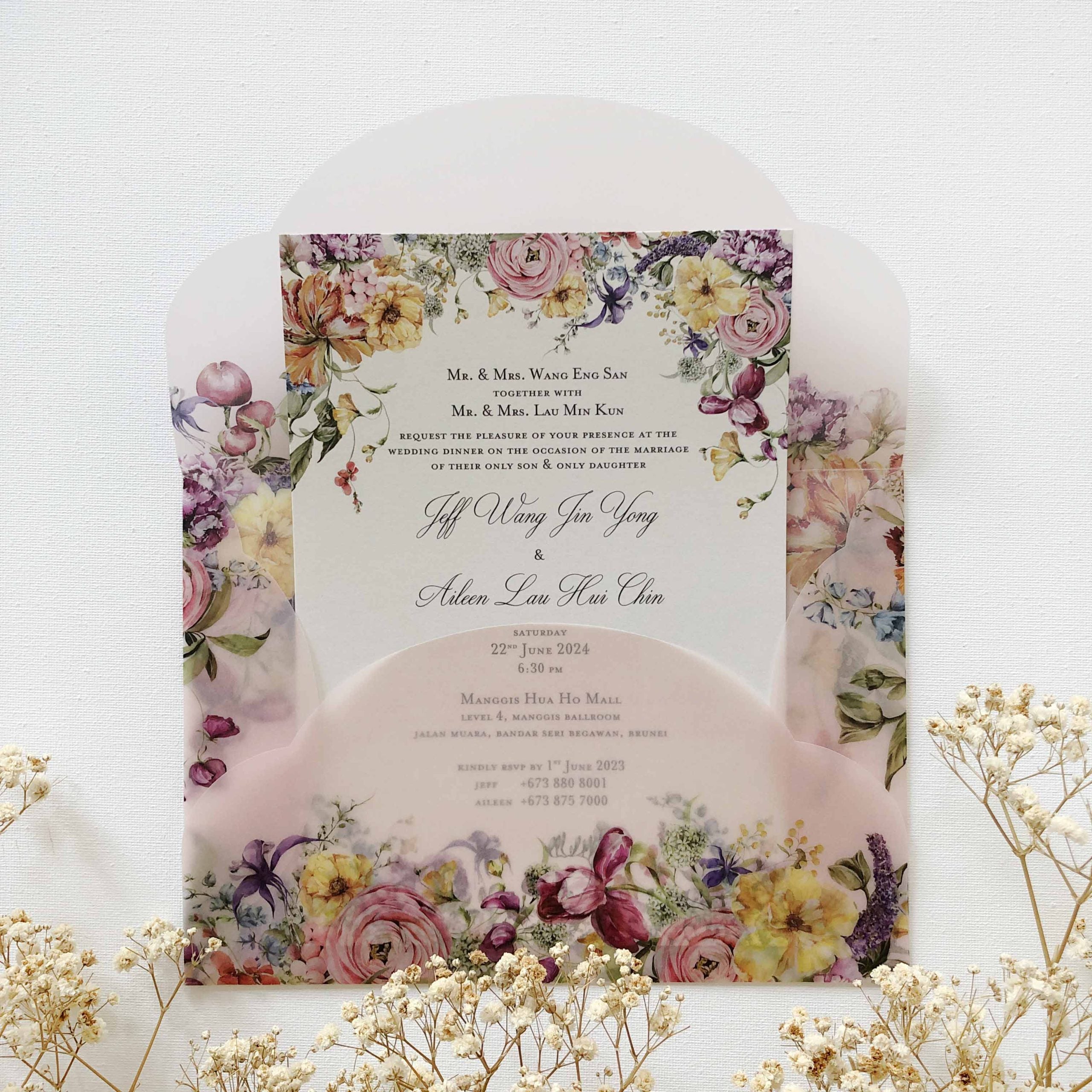Floral wedding invitation with a white envelope on a light background
