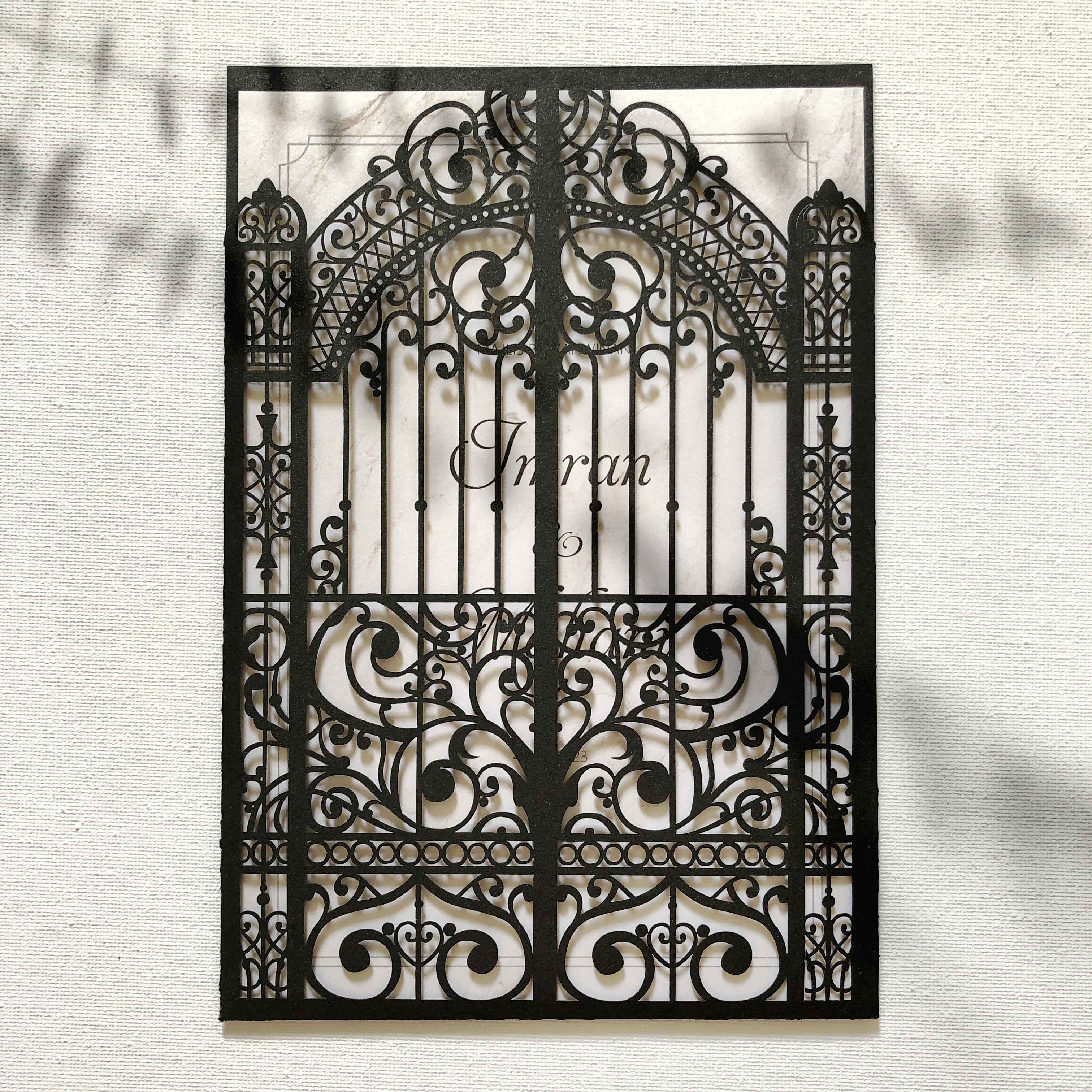 Decorative metal gate with intricate designs and the brand 'Inran' on a light background