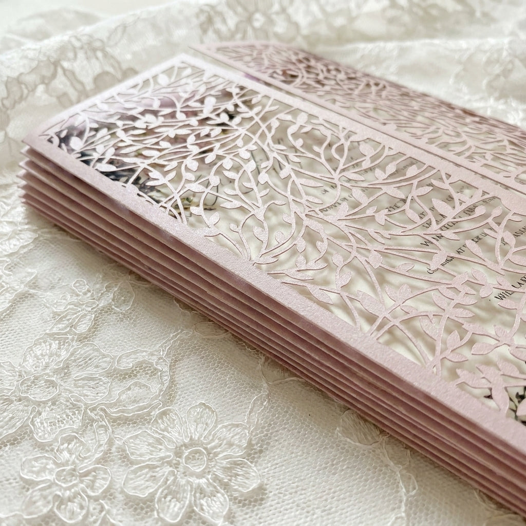 Stack of pink laser-cut cards on a textured white surface