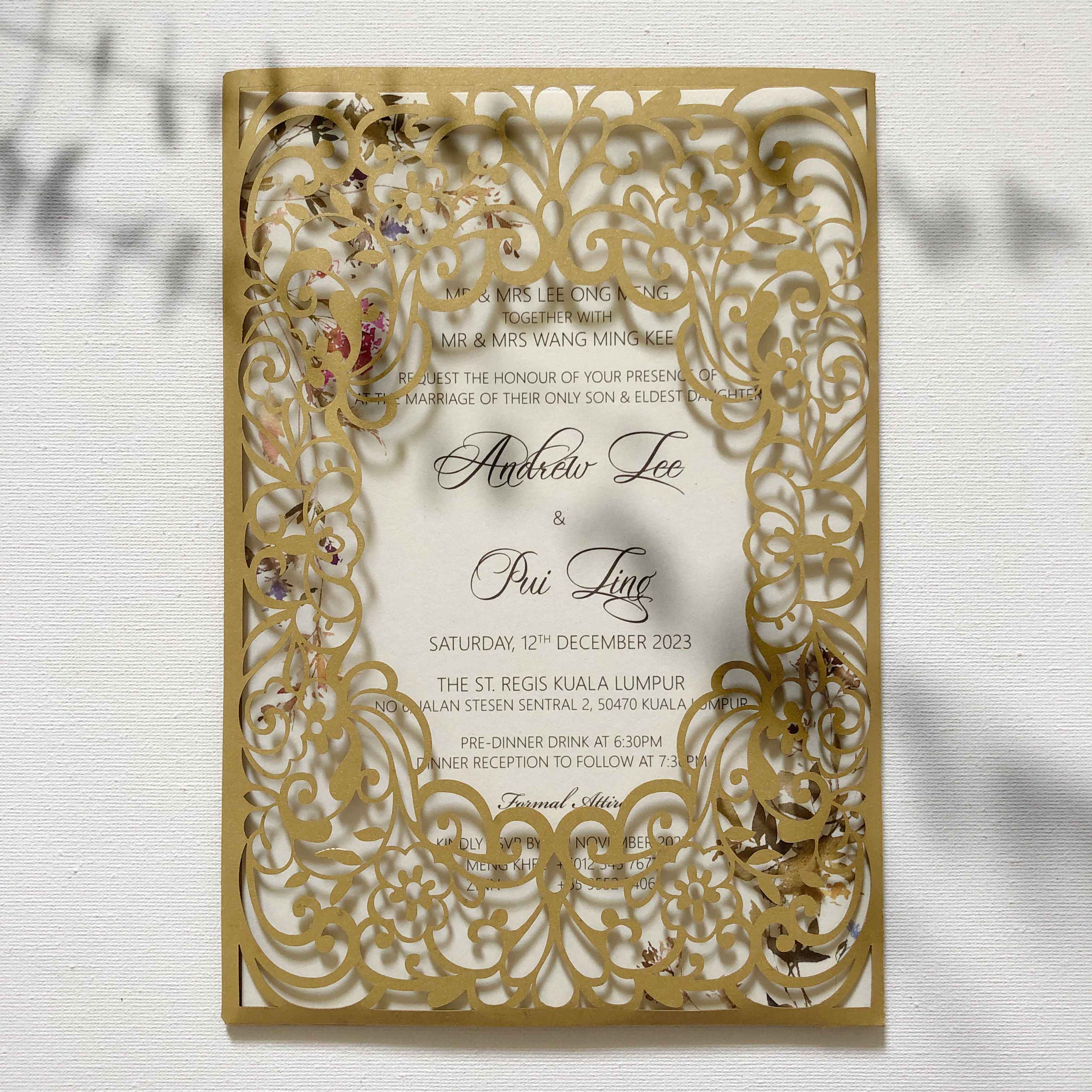 Decorative wedding invitation with gold and white intricate design on a light background