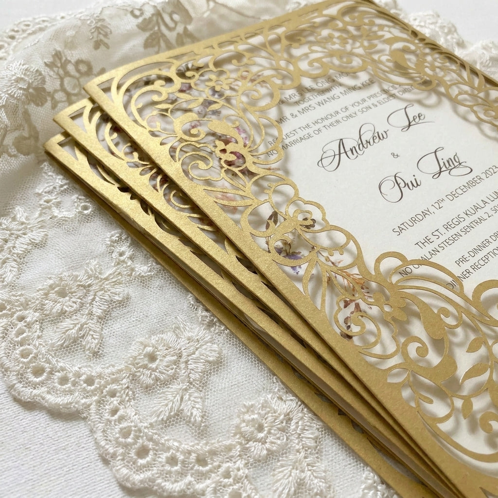 Gold laser-cut wedding invitation on a lace background